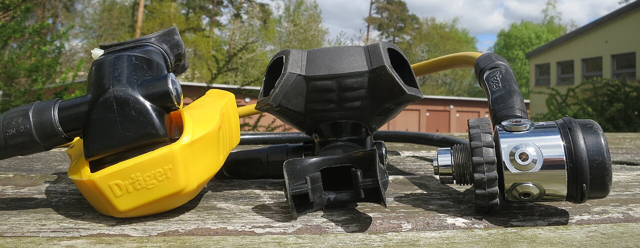 Historical Drager Shark regulator components photographed on a wooden surface