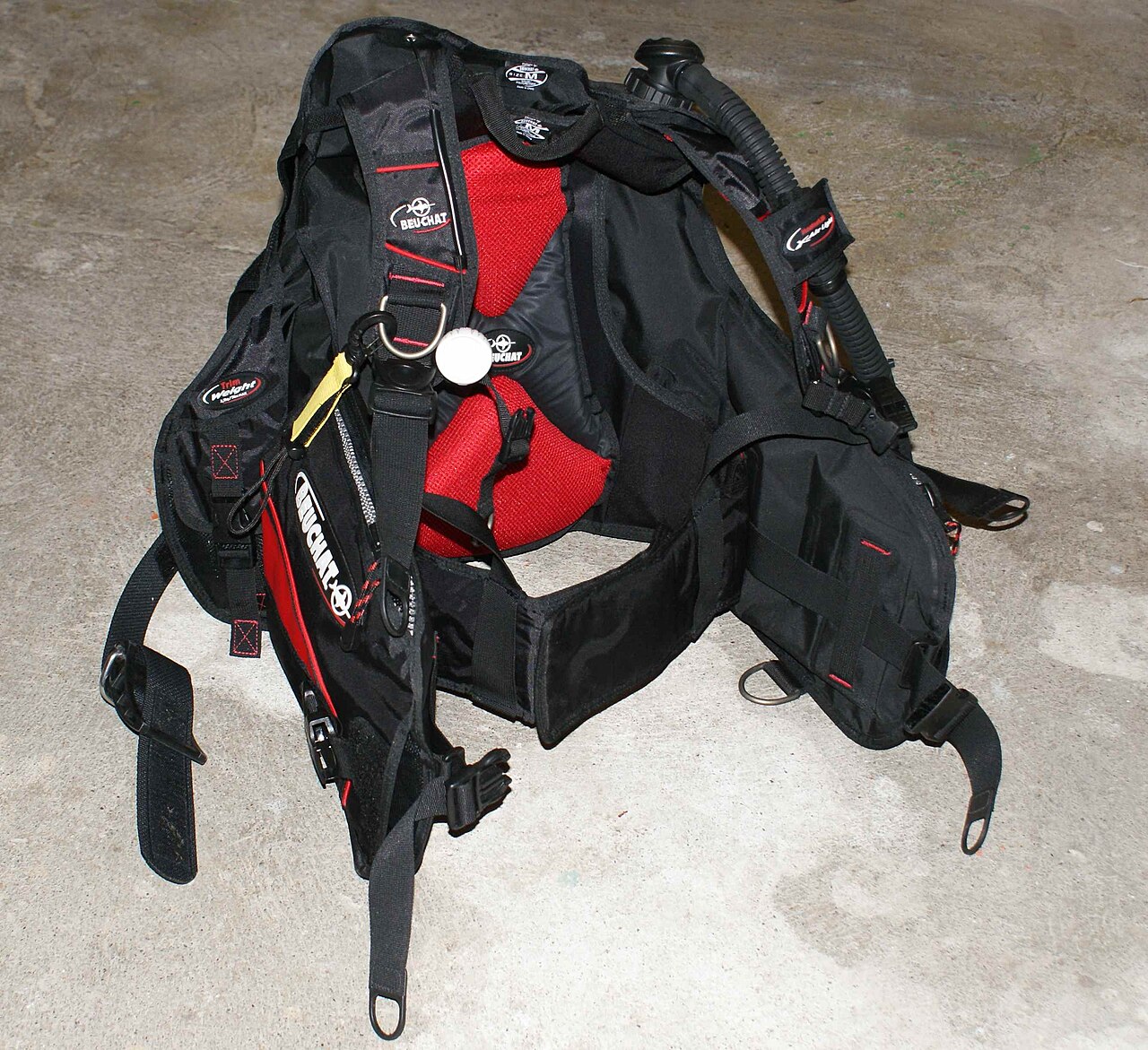 Black and red conventional buoyancy compensator laid out without a diver
