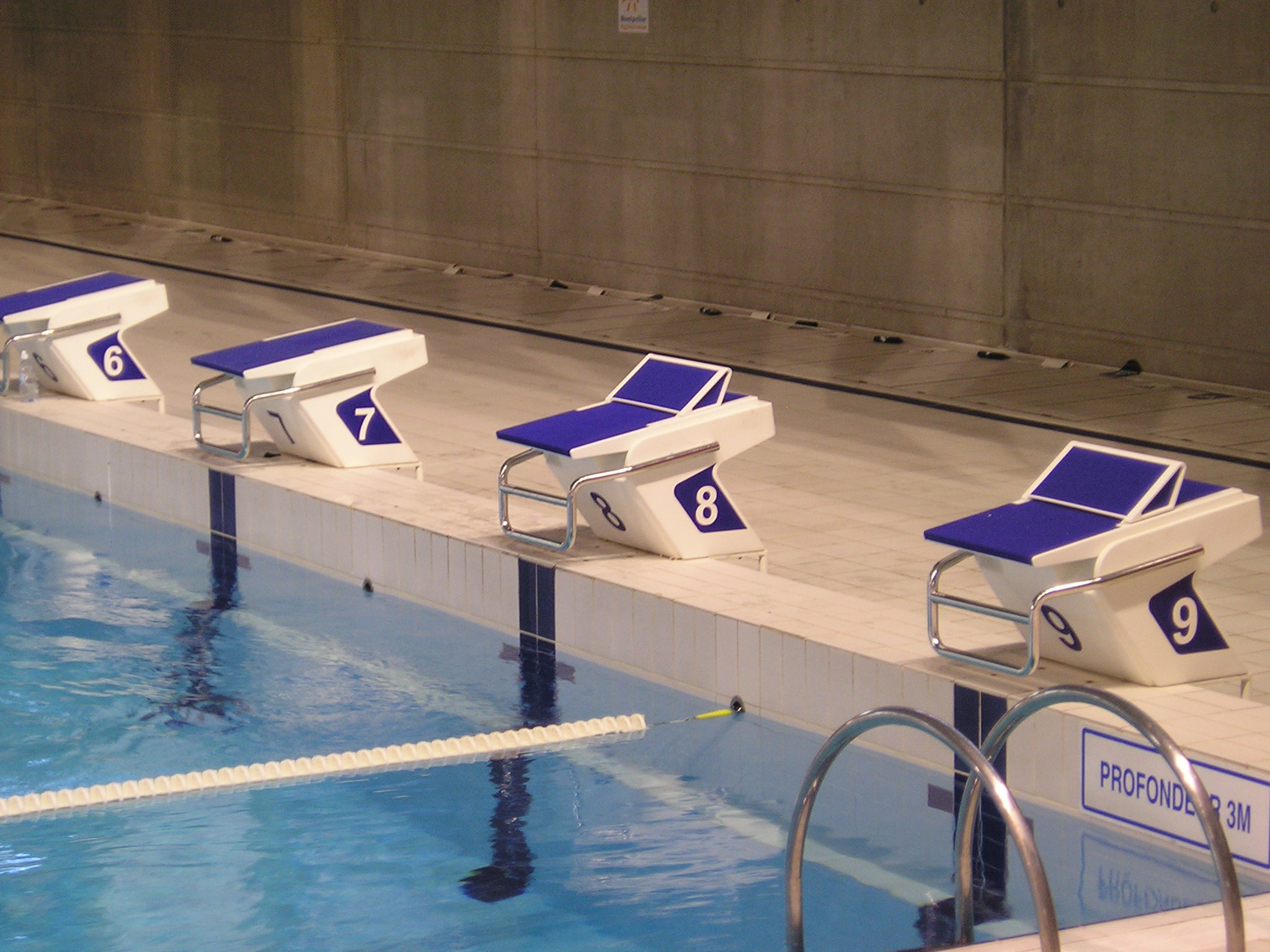 Unoccupied starting blocks and lane ropes at Montpellier Antigone swimming pool in October 2009, a different venue from the NSW course.