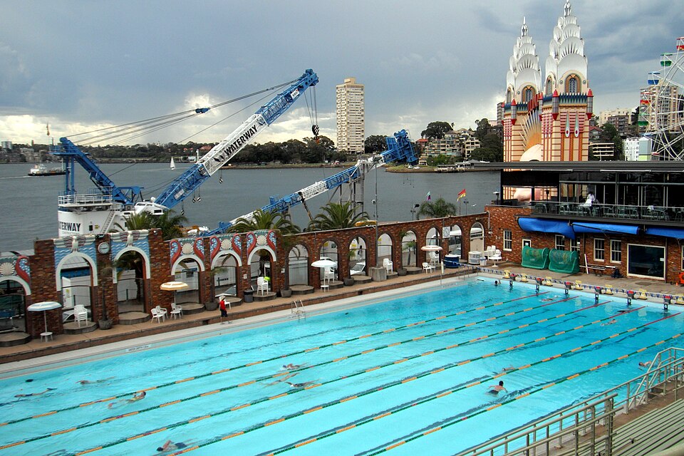 Historical wide view of swimmers in lanes at North Sydney Olympic Pool beside Luna Park in October 2010.