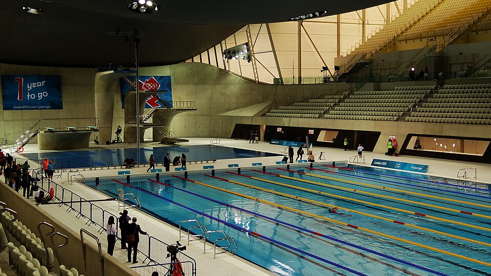 Wide historical view of swimming lanes and spectator seating at London Aquatics Centre in July 2011.
