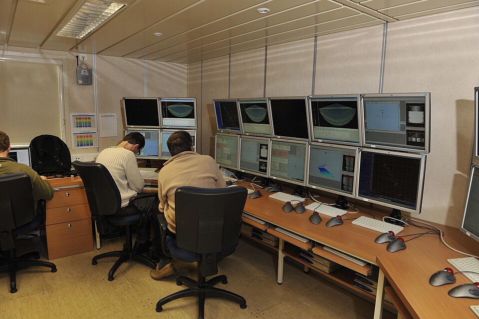 Historical wide view of echosounder screens and research staff seen from behind aboard Pourquoi pas during the December 2008 ESSRESON mission.