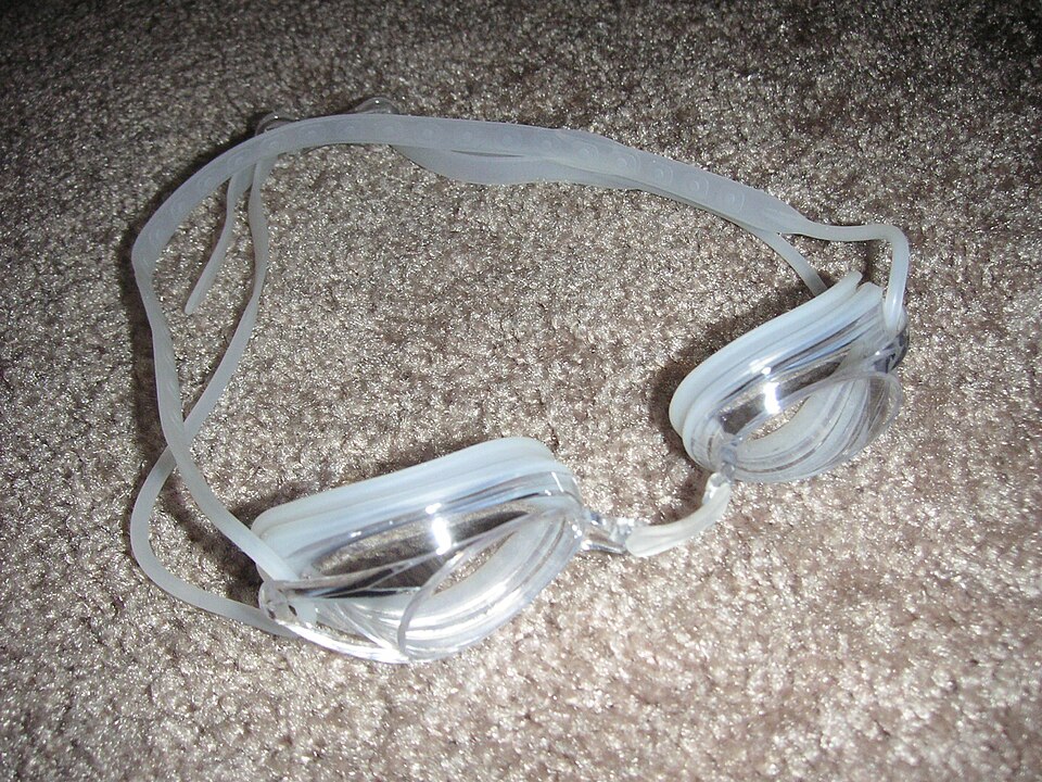 Real photograph of clear Nike Remora II swim goggles lying on a surface, used as archive equipment context.