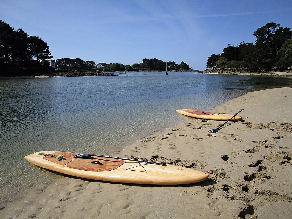 Wooden paddleboards beside calm water