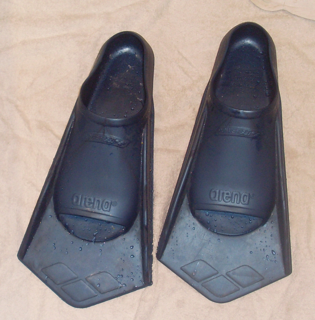 Archive pair of short swimming fins on a floor, not either current model compared in the article.