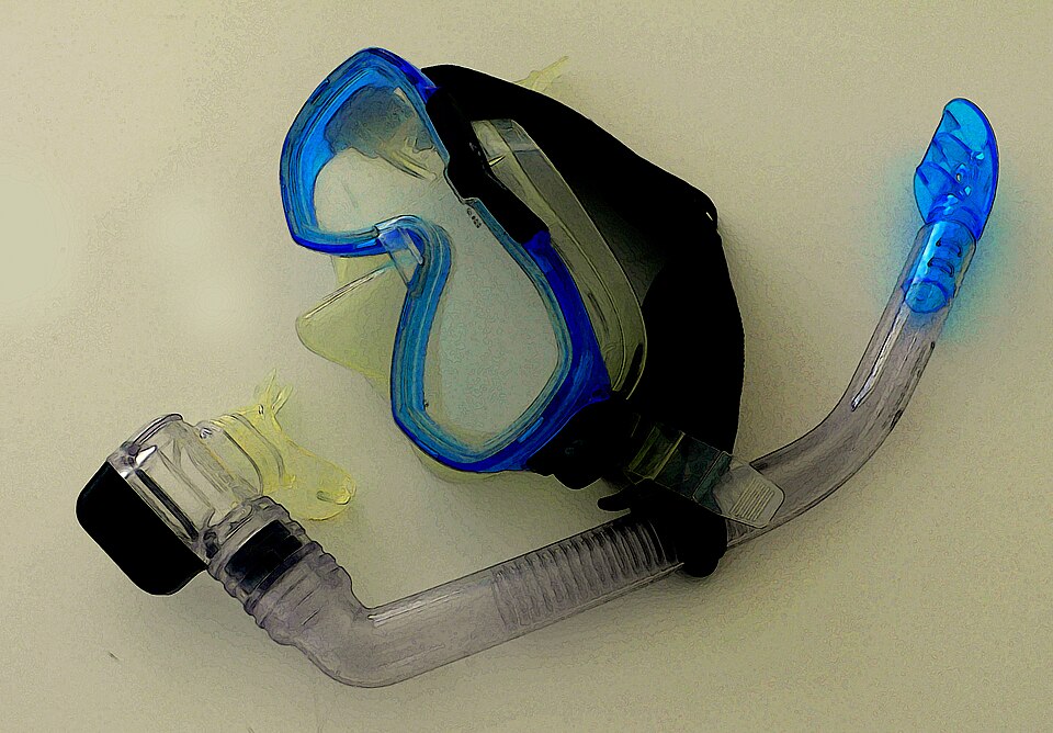 A blue mask and separate clear snorkel lie on a pale surface