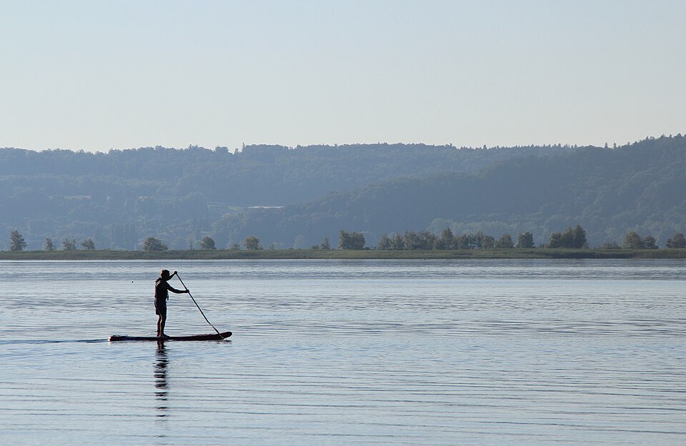 Distant silhouetted paddleboarder on Lake Biel