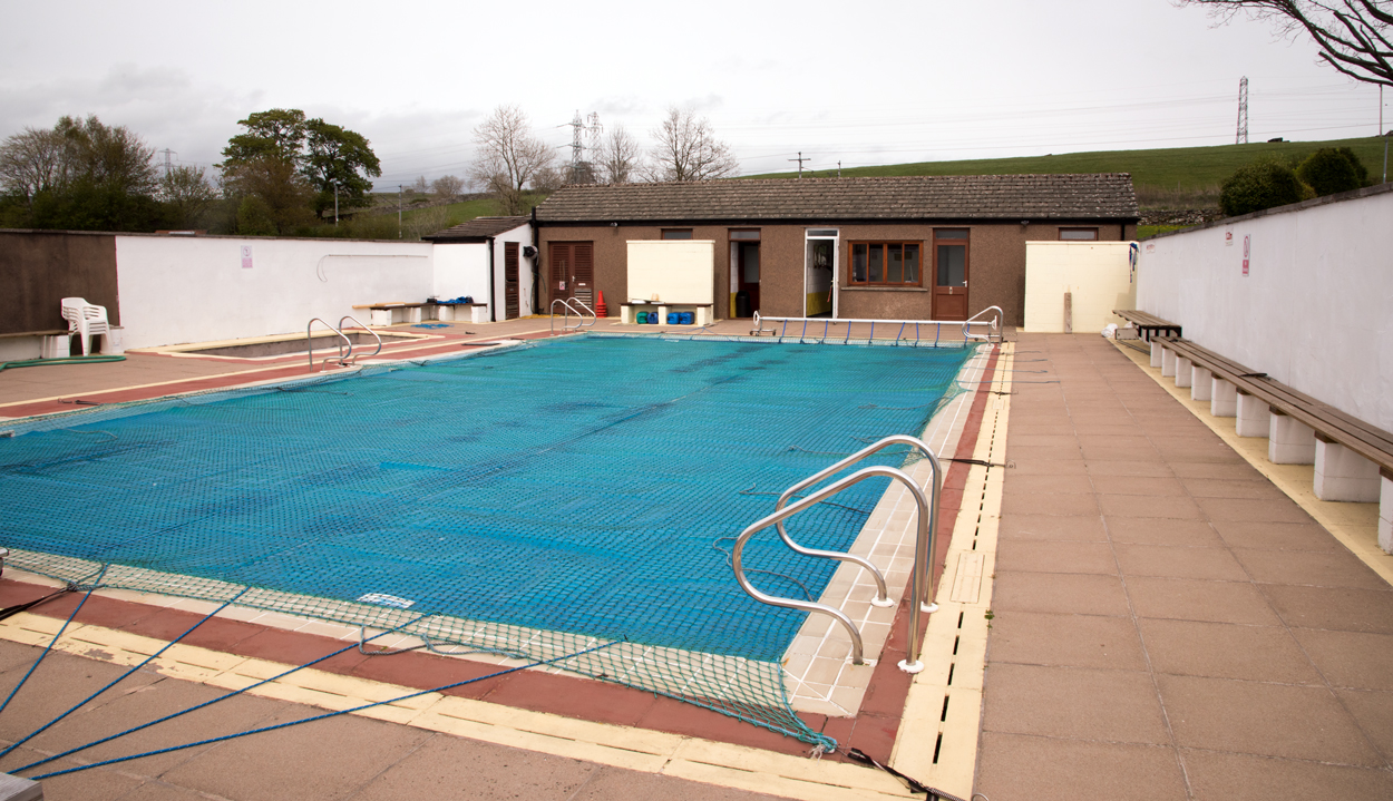 Archived photograph of an empty outdoor swimming pool and surrounding deck at Shap, England.