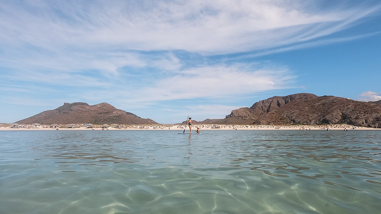 Paddleboarder on clear coastal water at Playa Balandra in Mexico