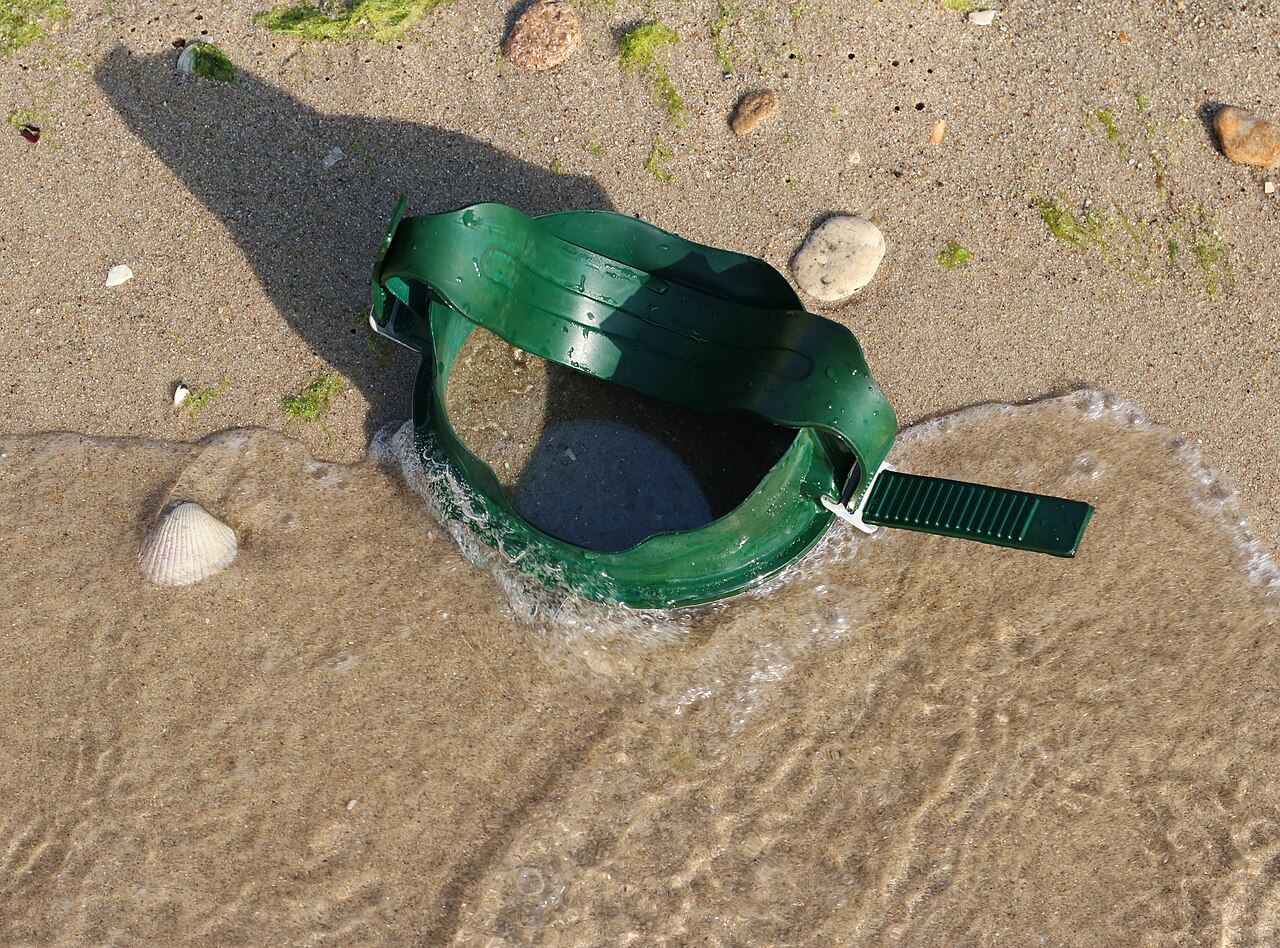 Green diving mask photographed at the shoreline in Chornomorsk